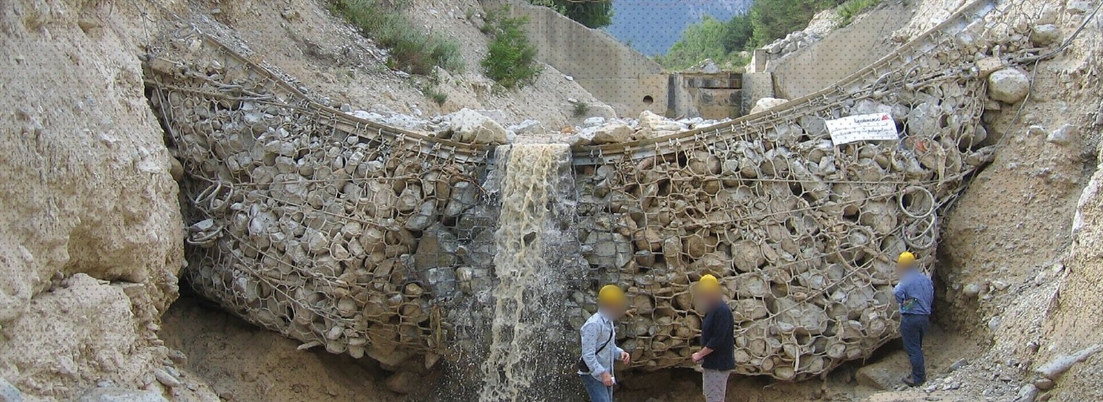 Filled debris flow barrier