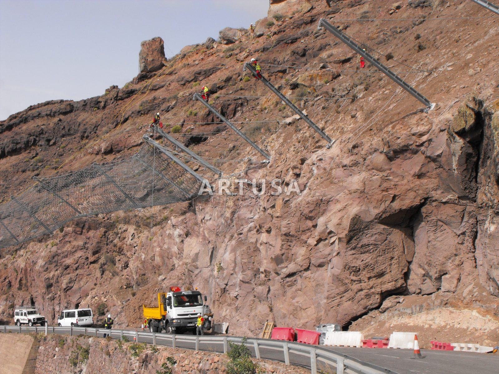 Anchored mesh and cable line on a red rock face