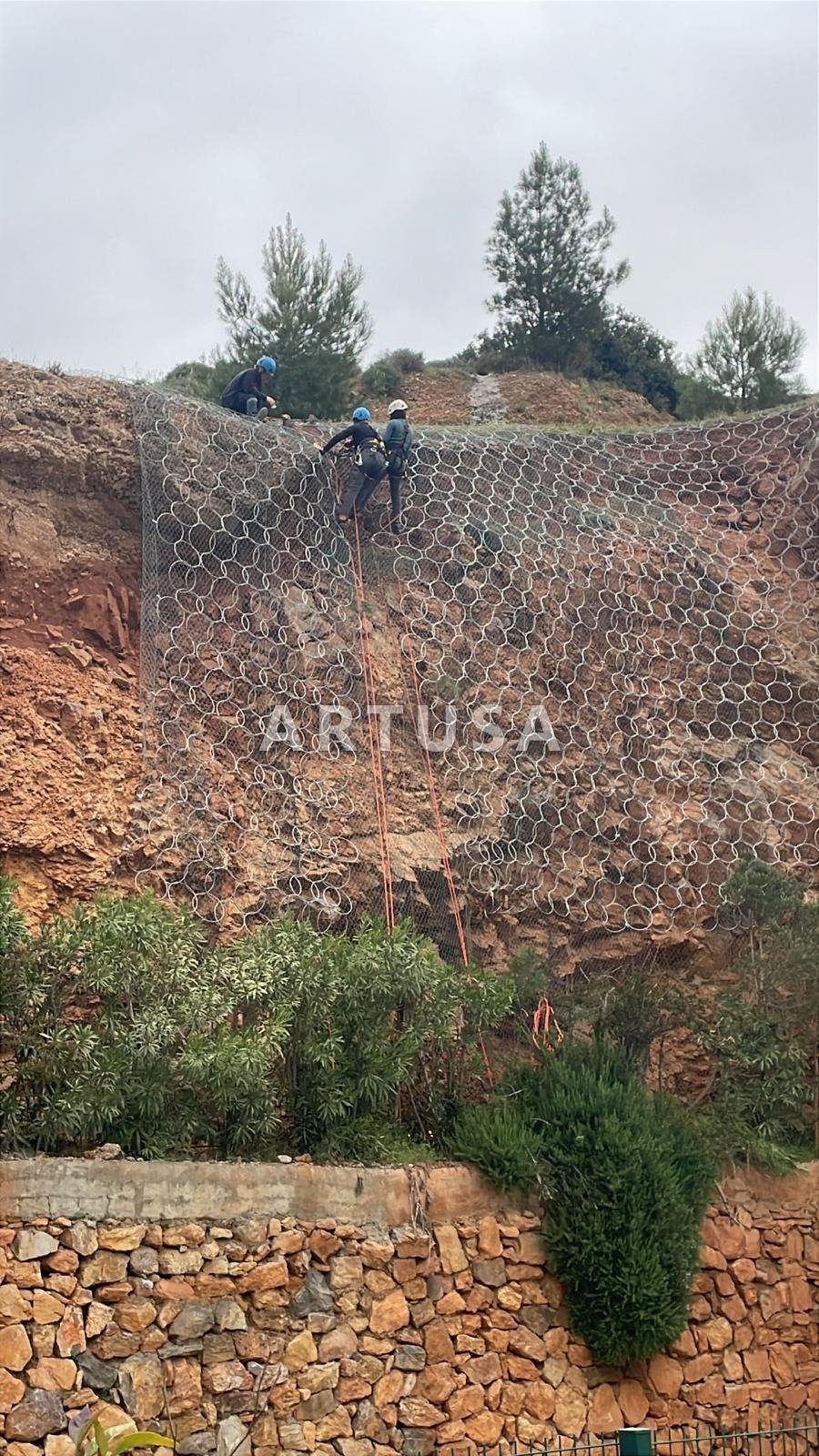 Mesh curtain installation on a slope